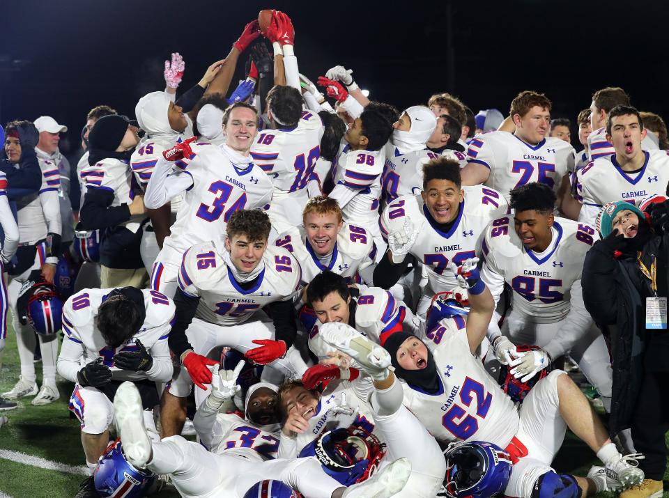 Carmel players celebrate their victory over Christian Brothers Academy in the Class AA state semifinal playoff game at Middletown High School Nov. 25, 2023.