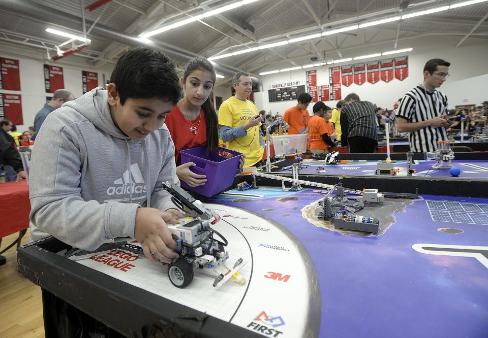 Avni Kathju, 11, and Karan Kad, 12, of Sewickley Academy change parts on their robot during the Western PA First Lego League competition at Sewickley Academy. More than 80 teams throughout western Pennsylvania participated in the robotics event in which students work together to solve a real-world problem. [Sally Maxson/BCT staff]