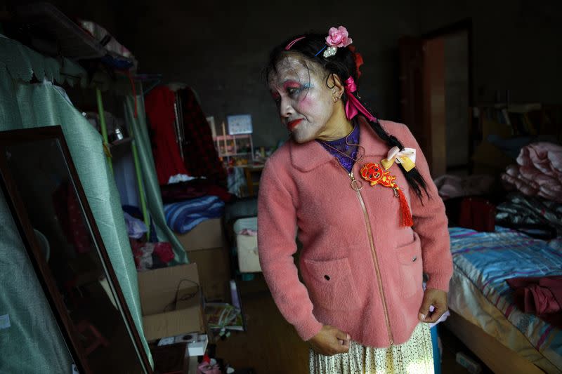 63-year-old transgender Liu Peilin tries on a new coat in front of a mirror at her bedroom in Guanzhong village, Fuzhou