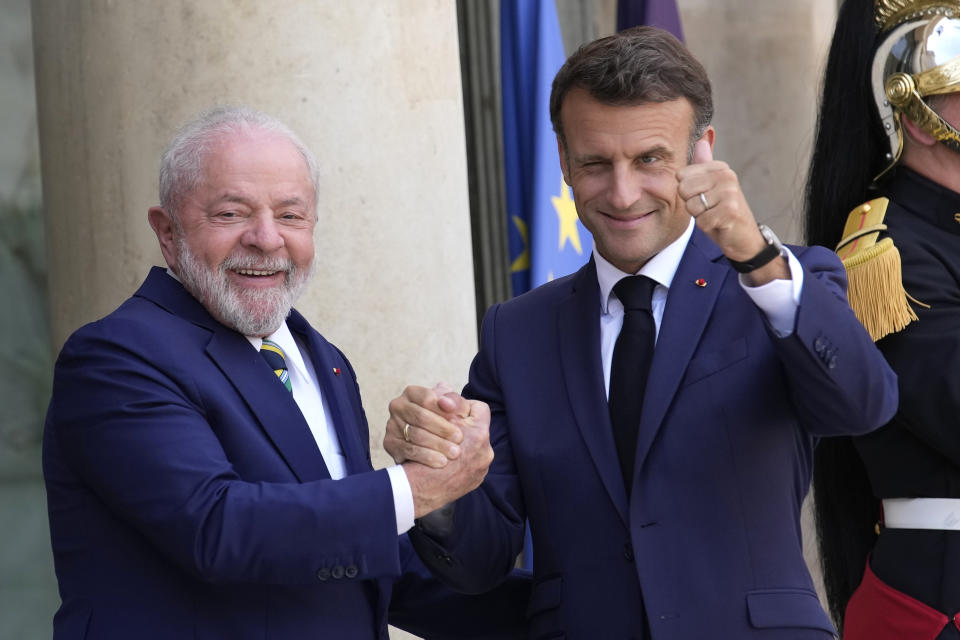 French President Emmanuel Macron, right, thumbs up as he welcomes Brazilian President Luiz Inacio Lula Da Silva before a working lunch Friday, June 23, 2023 at the Elysee Palace in Paris. World leaders and finance bosses were set to release a "to-do list" to help developing countries better tackle climate change and poverty, a long-sought goal of the two-day summit in Paris that wraps up on Friday. (AP Photo/Christophe Ena)