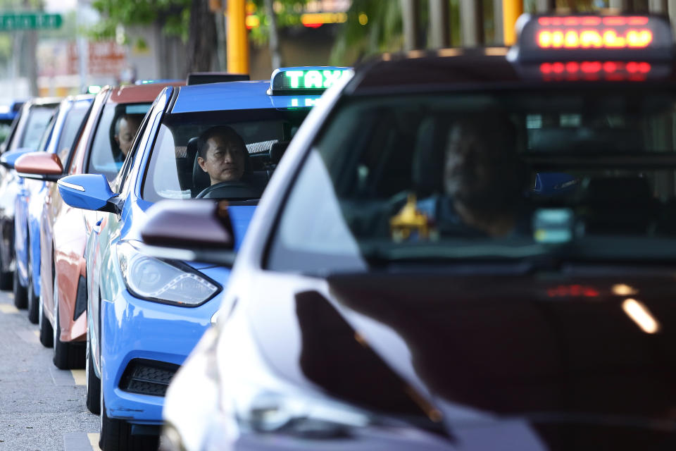SINGAPORE - MARCH 28:  Taxi drivers wait for customers at a taxi stand on March 28, 2020 in Singapore. Singapore government introduced a supplementary budget on March 26 with measures worth S$48 billion to support Singaporeans and businesses to cope with the Covid-19 pandemic.  (Photo by Suhaimi Abdullah/Getty Images)