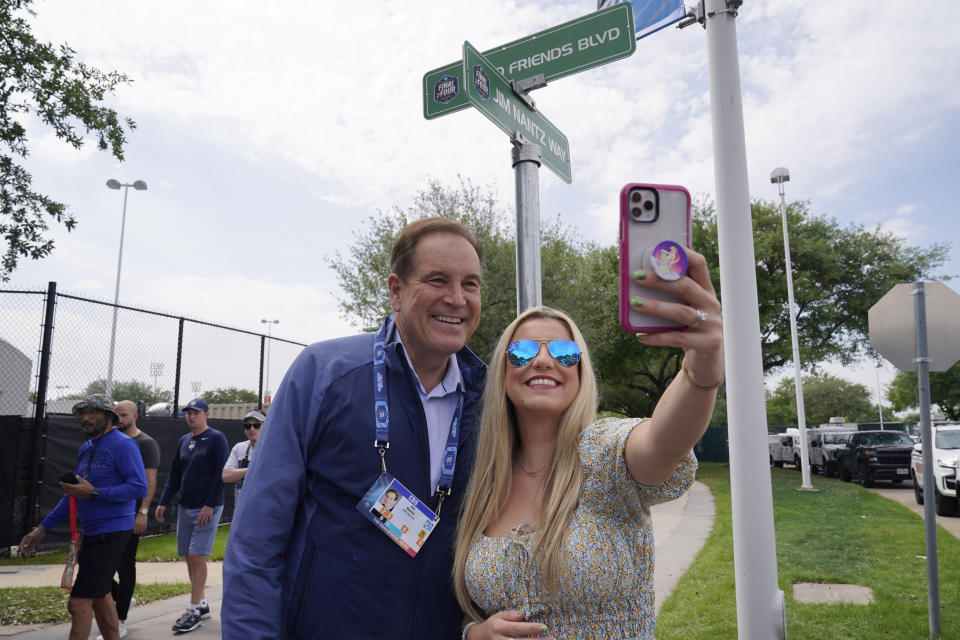 Jim Nantz, left, with his daughter Caroline Nantz, take a selfie with a Jim Nantz Way sign at NRG Stadium at the NCAA Tournament on Saturday, April 1, 2023, in Houston. (AP Photo/Godofredo A. Vasquez)
