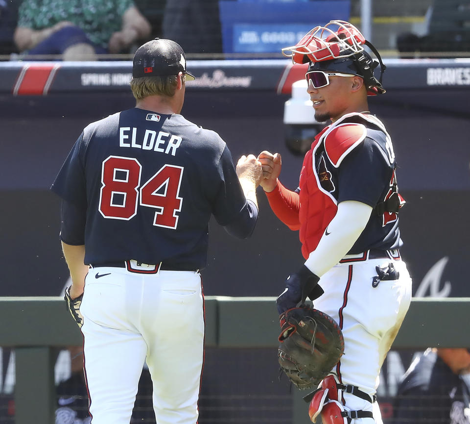 Atlanta Braves starting pitcher Bryce Elder gets a fist pump from catcher William Contreras in the third inning of a spring training baseball game against the Minnesota Twins in North Port, Fla., Friday, March 18, 2022. (Curtis Compton/Atlanta Journal-Constitution via AP)
