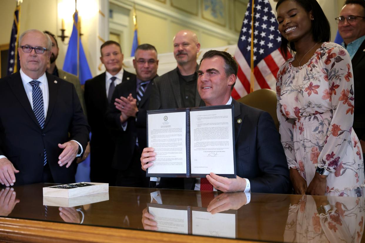 Oklahoma Gov. Kevin Stitt holds up an executive order relating to Diversity, Equity and Inclusion (DEI) on Wednesday in the Blue Room at the state Capitol in Oklahoma City.