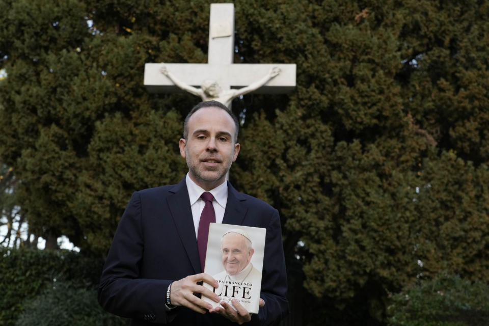 Italian journalist and writer Fabio Marchese Ragona holds a copy of "Life: My Story Through History" as he poses for a picture prior to the start of an interview with the Associated Press, in Rome, Thursday, March 13, 2024. Pope Francis says he has no plans to resign and isn't suffering from any health problems that would require doing so, in an autobiography, "Life: My Story Through History," which is being published Tuesday and written with Italian journalist Fabio Marchese Ragona. (AP Photo/Gregorio Borgia)