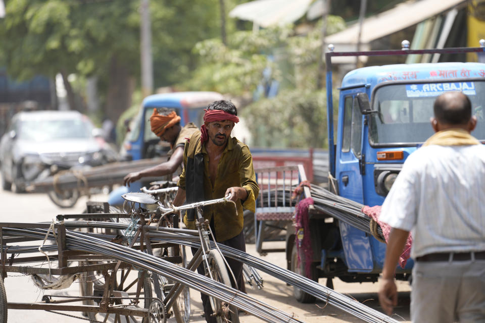 A laborer transports iron rods on a cycle rickshaw on a hot summer day in Prayagraj, northern Uttar Pradesh state India, Monday, May 22, 2023. The heat wave in the state is likely to continue for another two days, an Indian Meteorological Department official said. (AP Photo/Rajesh Kumar Singh)