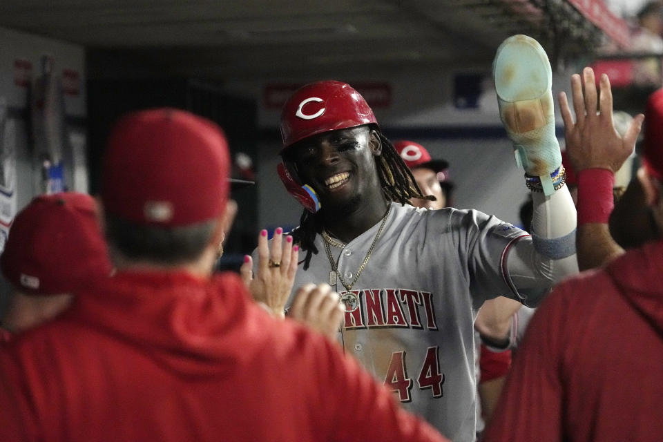 Cincinnati Reds' Elly De La Cruz is congratulated by teammates in the dugout after scoring on a double by Spencer Steer during the fifth inning of a baseball game against the Los Angeles Angels Tuesday, Aug. 22, 2023, in Anaheim, Calif. (AP Photo/Mark J. Terrill)