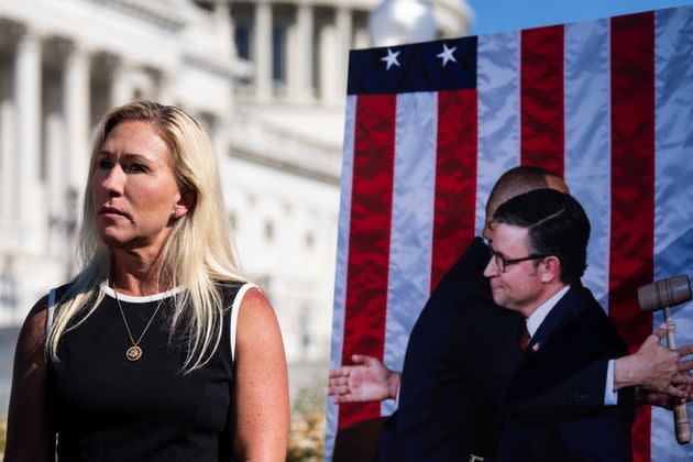 Rep. Marjorie Taylor Greene (R-Ga.), standing by a poster of House Speaker Mike Johnson and Minority Leader Hakeem Jeffries, holds a news conference Wednesday at the U.S. Capitol to announce she is moving forward with her effort to depose Johnson.