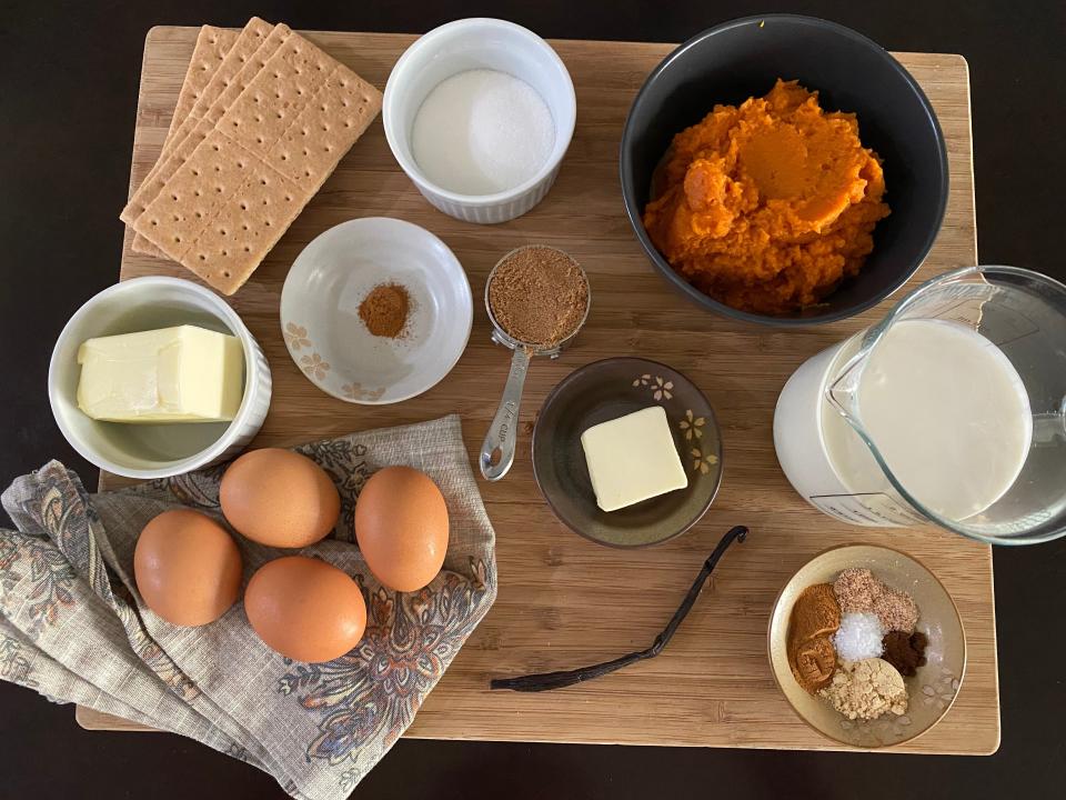 The ingredients laid out on a wooden cutting board for Bobby Flay's pumpkin pie