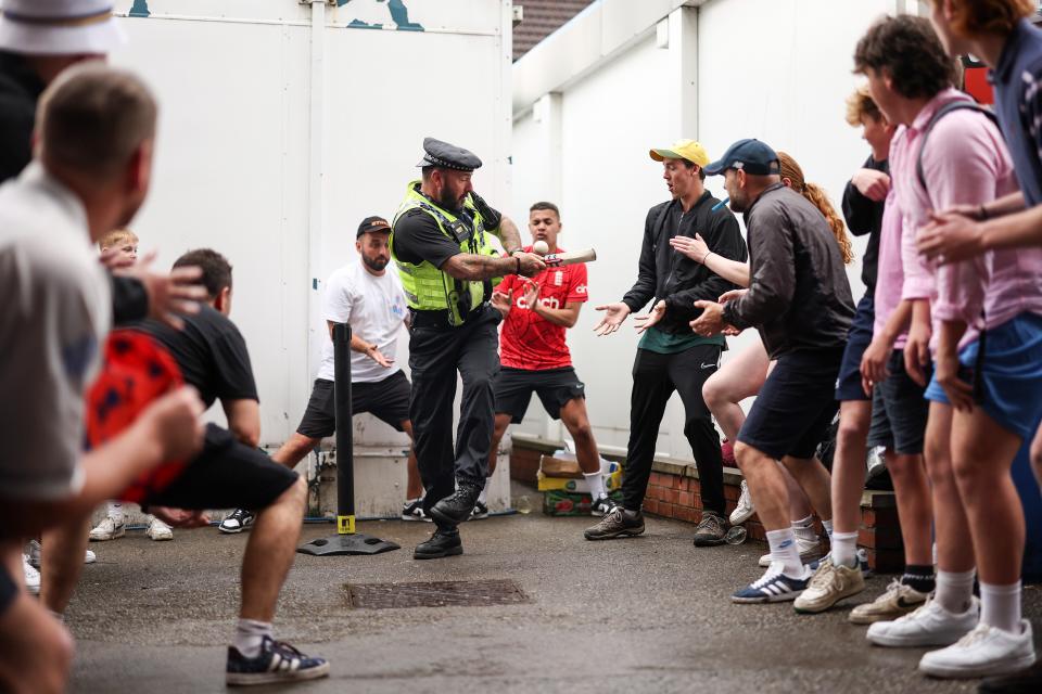 A policeman joins in on the cricket action with the rain delays postponing the game on the field (Getty Images)