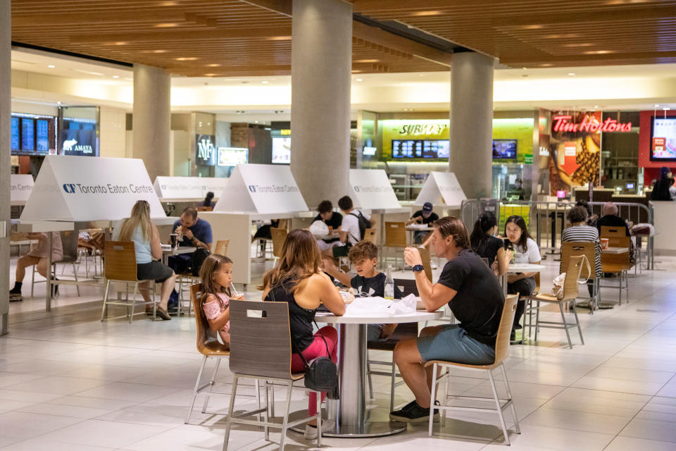 People eat in the foodcourt at the Eaton Centre shopping centre after indoor dining restaurants, gyms and cinemas re-open under Phase 3 rules from coronavirus disease (COVID-19) restrictions in Toronto, Ontario, Canada July 31, 2020.  REUTERS/Carlos Osorio