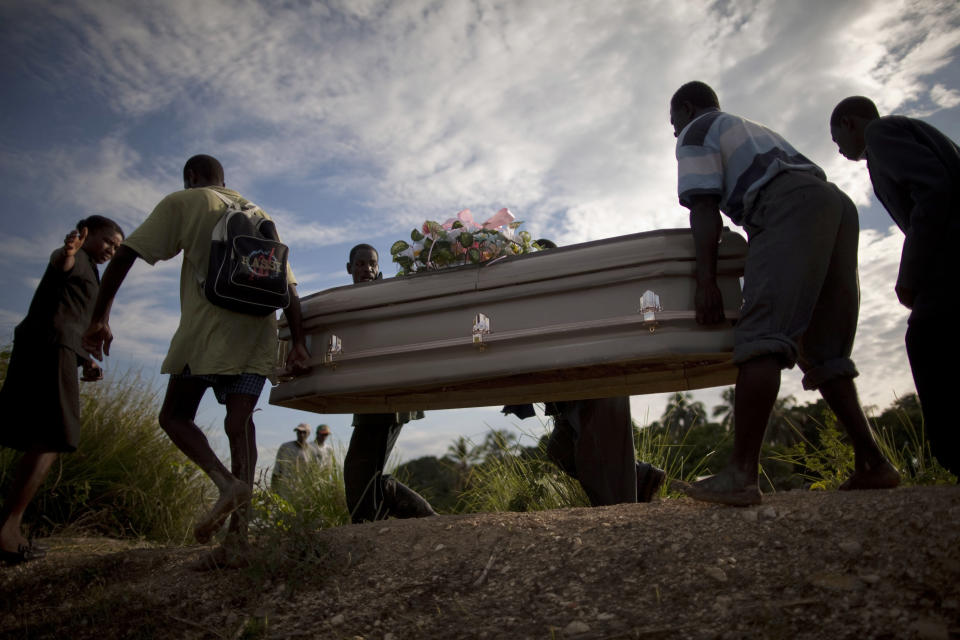 <p>People carry a coffin containing the remains of a relative who died of cholera in Robine, Haiti, Saturday Oct. 23, 2010. A spreading cholera outbreak in rural Haiti threatened to outpace aid groups as they stepped up efforts Saturday hoping to keep the disease from reaching the camps of earthquake survivors in Port-au-Prince. Health officials said at least 208 people had died. (Photo: Ramon Espinosa/AP) </p>