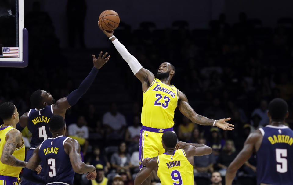 Los Angeles Lakers forward LeBron James (23) grabs a rebound over Denver Nuggets forward Paul Millsap (4) during the first half of an NBA preseason basketball game, Sunday, Sept. 30, 2018, in San Diego. (AP Photo/Gregory Bull)