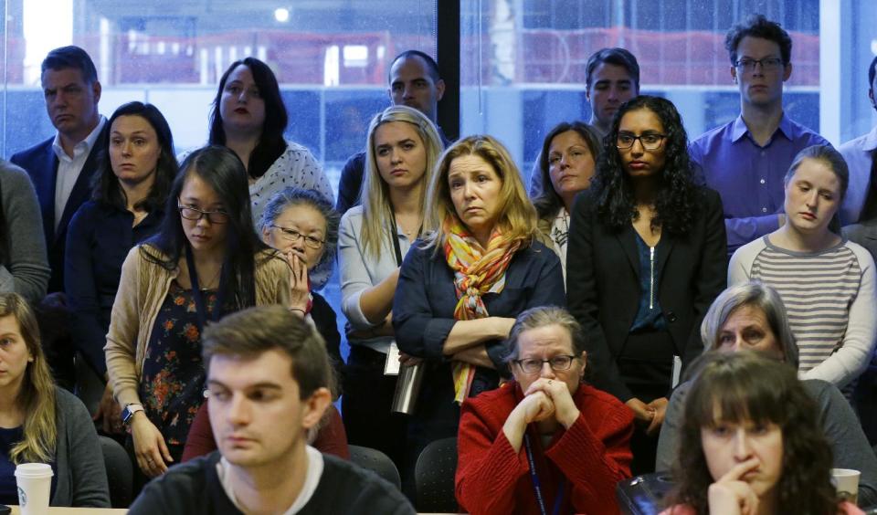 A group of people including employees of the Washington state Attorney General's office stands and listens in the back of a briefing room during a news conference Monday, Jan. 30, 2017, in Seattle. Attorney General Bob Ferguson announced that he is suing President Donald Trump over an executive order that suspended immigration from seven countries with majority-Muslim populations and sparked nationwide protests. (AP Photo/Ted S. Warren)