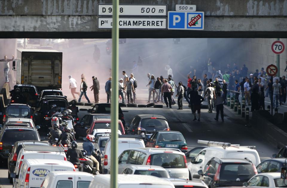 French taxi drivers, who are on strike, block the traffic on the Paris ring road during a national protest against car-sharing service Uber, in Paris, France, June 25, 2015. (REUTERS/Charles Platiau)