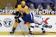 Nashville Predators center Yakov Trenin (13) tries to stop Tampa Bay Lightning right wing Barclay Goodrow (19) from getting to the puck during the first period of an NHL hockey game Tuesday, April 13, 2021, in Nashville, Tenn. (AP Photo/Mark Zaleski)