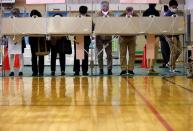 Voters prepare to cast their ballots in the lower house election, amid the coronavirus disease (COVID-19) pandemic, at a polling station in Tokyo