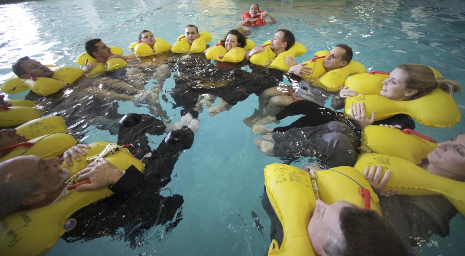 In this photo made Thursday, Jan. 26, 2012, members of the Megado frequent fliers group float in a circle during a water aircraft landing emergency exercise at the American Airlines training facility in Fort Worth, Texas. In the ultimate field trip for aviation geeks, 160 of frequent fliers chartered an American Airlines jet and hoped across the country visiting aviation industry spots. (AP Photo/LM Otero)