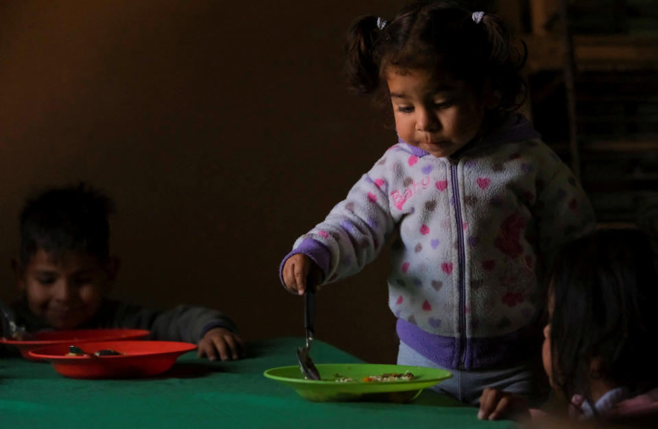 Sofia Laguna, de 2 años, come una ración de guiso en un comedor social donde su madre trabaja como cocinera voluntaria, en Salta, Argentina, el 17 de septiembre de 2024. REUTERS/Javier Corbalan/Foto de archivo