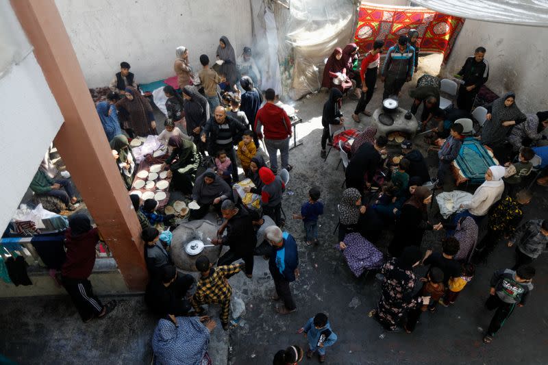 Palestinos desplazados cocinan en una escuela que acoge a personas que huyeron de sus casas debido a los ataques israelíes, en Rafah, en el sur de la Franja de Gaza