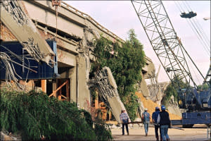 CHRIS WILKINS-AFP/Getty ImagesCaltrans workers carry materials to be used as reinforcement of the quake-ravaged Cypress Structures on Interstate 880 22 October 1989