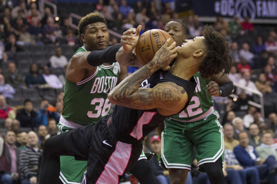 Boston Celtics guard Marcus Smart (36) reaches as Washington Wizards forward Kelly Oubre Jr. (12) attempts a shot during the first half of an NBA basketball game Wednesday, Dec. 12, 2018, in Washington. (AP Photo/Alex Brandon)