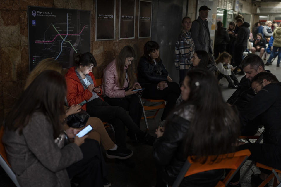 People sit in the Kyiv subway, using it as a bomb shelter, in Kyiv, Ukraine, on Wednesday, Oct. 19, 2022. (AP Photo/Emilio Morenatti)