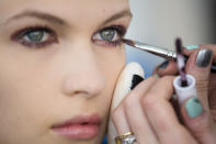 A model has her make-up applied backstage before the Sophie Theallet Spring 2013 collection is modeled during Fashion Week in New York, Tuesday, Sept. 11, 2012. (AP Photo/John Minchillo)