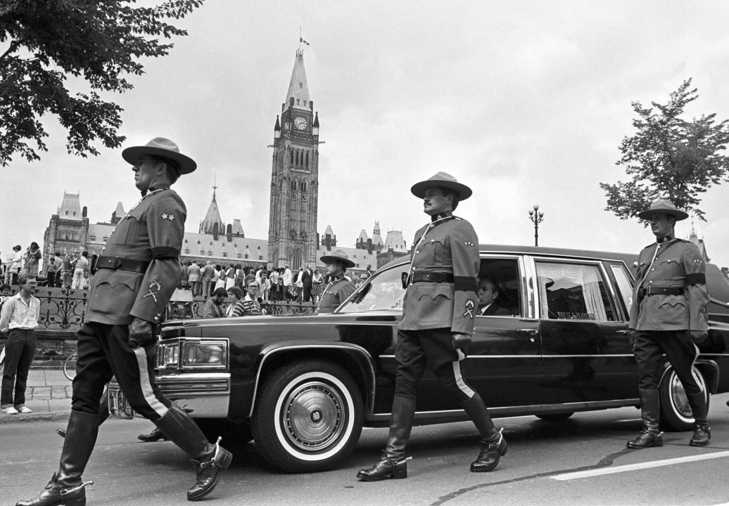 The casket of former Prime Minister John Diefenbaker riding in a hearse as members of the RCMP walk along during his state funeral, Aug 19, 1979.  THE CANADIAN PRESS/Peter Bregg