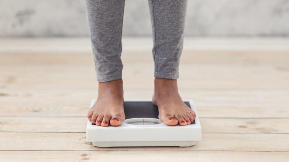 Black woman steps on weighing scale thegrio.com