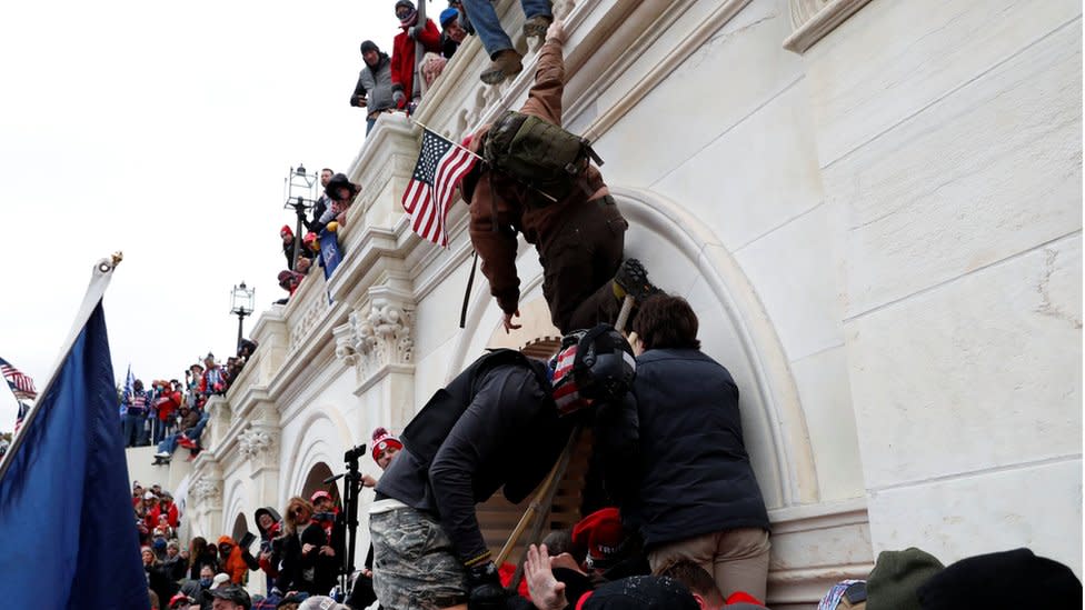 Simpatizantes de Trump escalando los muros del Capitolio