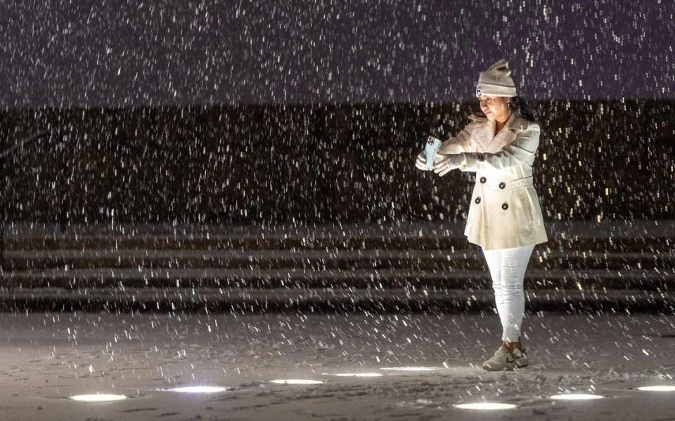 Viviana Torres takes a selfie as snow falls at the World War I Museum and Memorial on Saturday, Nov. 25, 2023, in Kansas City.