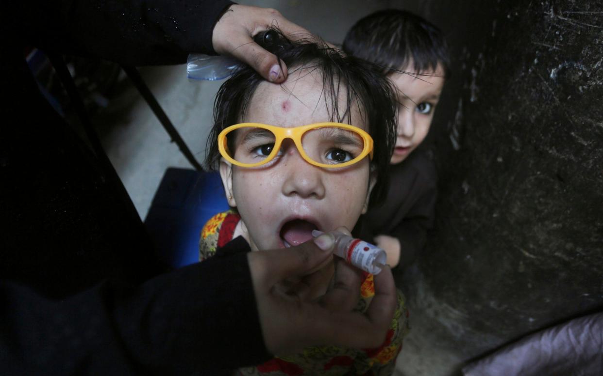 A child is vaccinated against polio in Lahore, Pakistan - AP