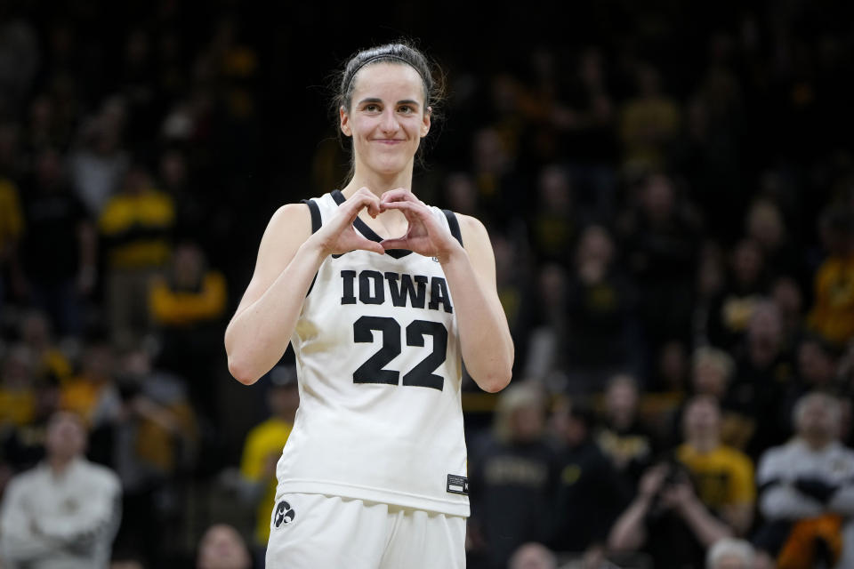 Iowa guard Caitlin Clark makes a heart gesture after the team's NCAA college basketball game against Michigan, Thursday, Feb. 15, 2024, in Iowa City, Iowa. Clark broke the NCAA women's career scoring record. (AP Photo/Matthew Putney)