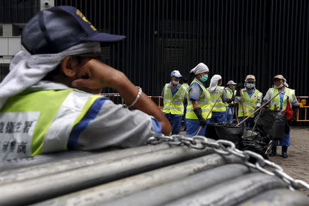 Cleaning workers gather for a cleanup outside the government headquarters in Hong Kong, China June 24, 2015. REUTERS/Bobby Yip