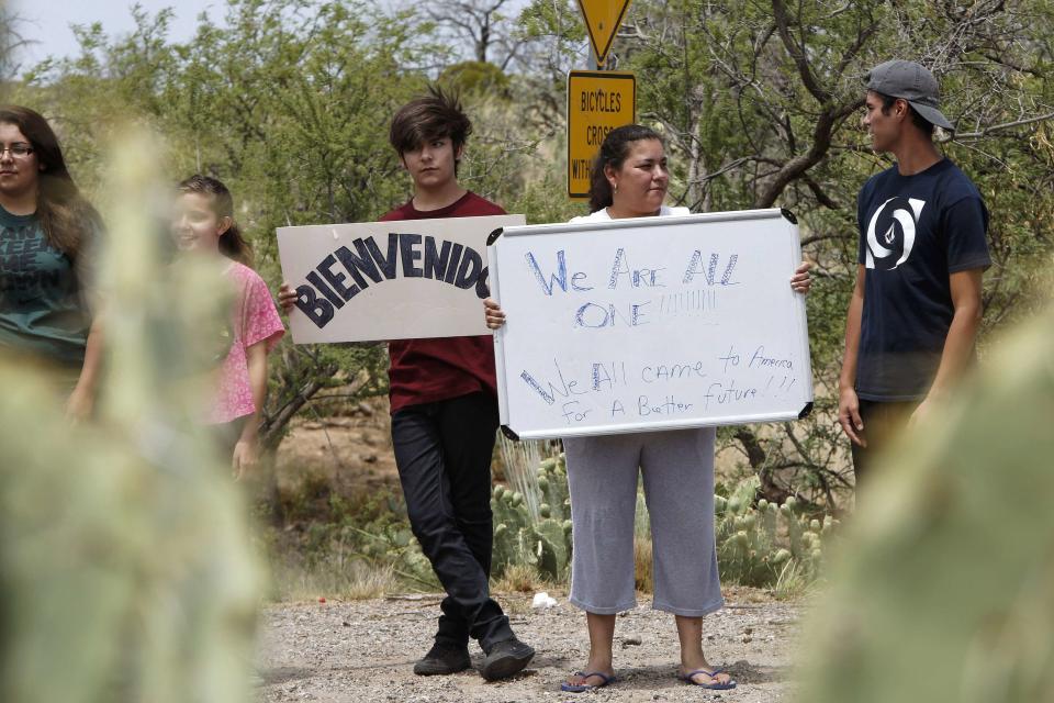 Amelia Martinez of Oracle holds up a sign as she and members of her family gather in support of undocumented immigrants in Oracle, Arizona July 15, 2014. In a scene reminiscent of similar protests in California, about 65 demonstrators gathered against the arrival of undocumented immigrants near the small town of Oracle. They complained that the federal government's response to a surge of new arrivals from Central America was putting their communities at risk. The sign (L) reads, "welcome". REUTERS/Nancy Wiechec (UNITED STATES - Tags: SOCIETY IMMIGRATION CIVIL UNREST)