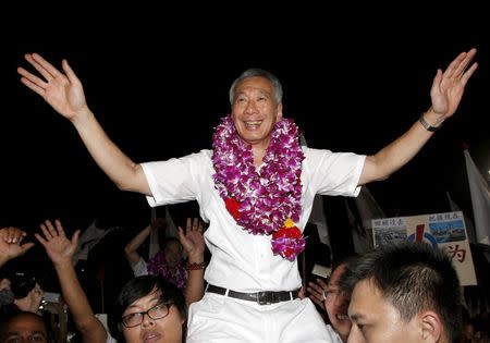 FILE PHOTO Singapore's Prime Minister and Secretary-General of the People's Action Party Lee Hsien Loong (C) celebrates with supporters after the general election results at a stadium in Singapore September 12, 2015. REUTERS/Edgar Su/File Photo