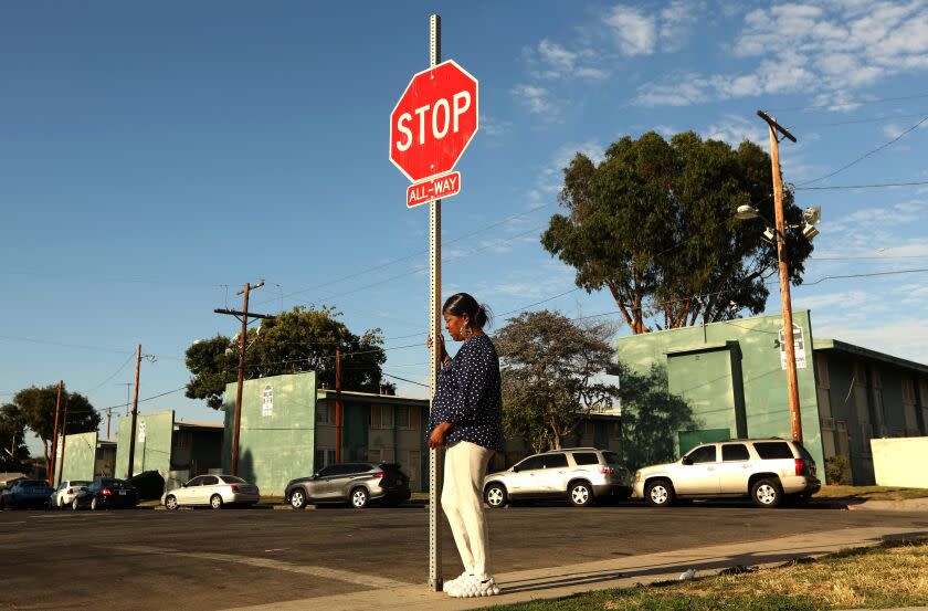 WATTS, CA - AUGUST 1, 2023 - Dr. Cynthia "Big Mama" Mendenhall waits for a friend under a symbolic sign with her wishes for gun violence to end at the Imperial Courts housing project in Watts on August 1, 2023. Dr. Mendenhall was waiting for a friend to meet her at the spot. She lost two sons to gun violence in 2006 and continues to live in Imperial Courts. Watts has been the site of violence in recent weeks with multiple people dying and 9 people being shot in Imperial Courts and Jordan Downs housing projects. (Genaro Molina / Los Angeles Times)