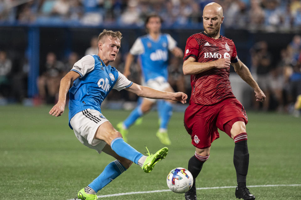 Charlotte FC forward Karol Świderski, left, and Toronto FC midfielder Michael Bradley, right, fight for the ball during the first half of an MLS soccer match, Saturday, Aug. 27, 2022, in Charlotte, N.C. (AP Photo/Matt Kelley)