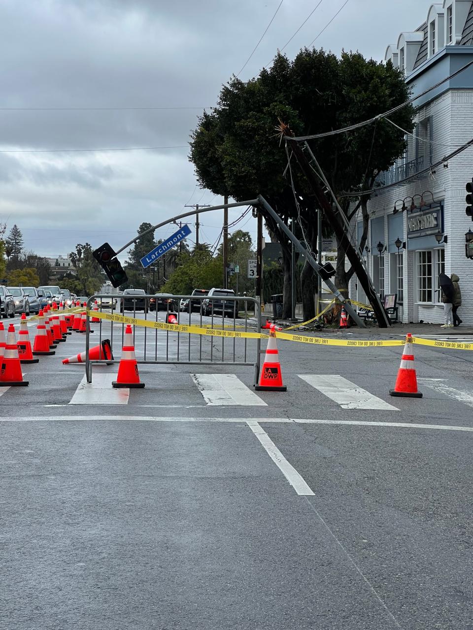 An electric pole and traffic light knocked over due to storms at an intersection in LA's Larchmont Village neighborhood. Some residents in the neighborhood were left without power for more than 12 hours Saturday, causing temperatures in their homes to drop into the 50s.