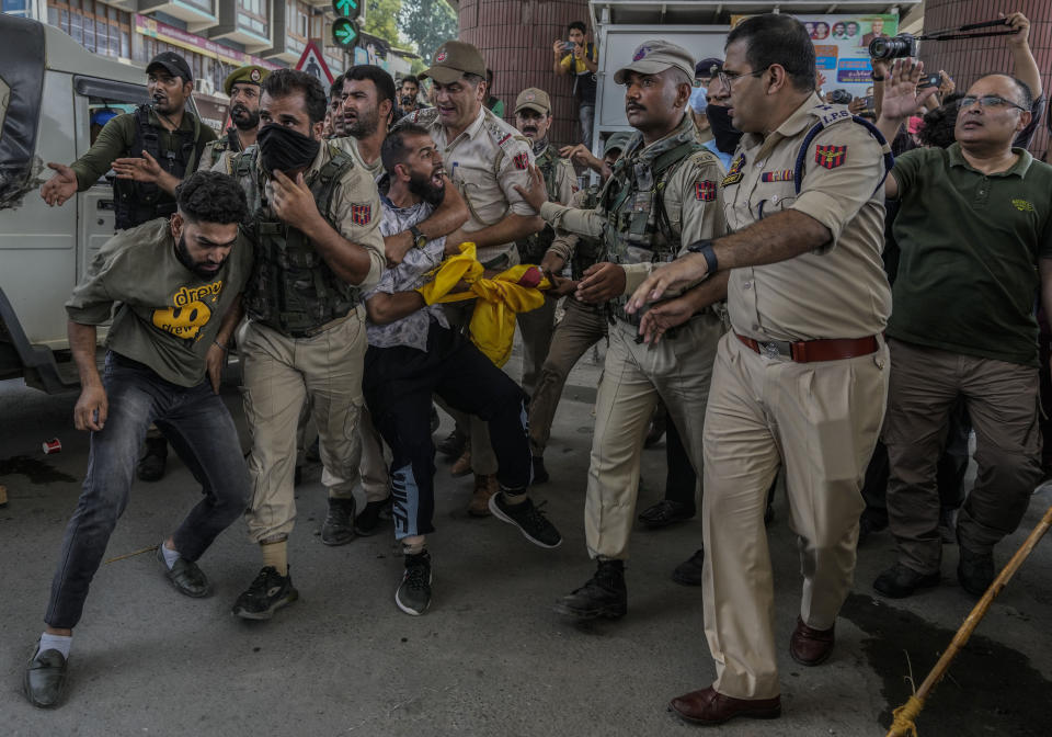 Indian policemen detain Kashmiri Shiite Muslims for participating in a religious procession during restrictions in Srinagar, Indian controlled Kashmir, Sunday, Aug. 7, 2022. Authorities had imposed restrictions in parts of Srinagar, the region's main city, to prevent gatherings marking Muharram from developing into anti-India protests. (AP Photo/Mukhtar Khan)