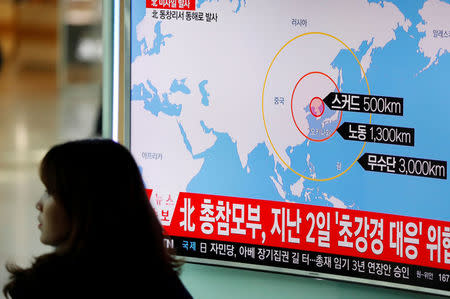 A woman walks past a television broadcasting a news report on North Korea firing ballistic missiles, at a railway station in Seoul, South Korea, March 6, 2017. REUTERS/Kim Hong-Ji