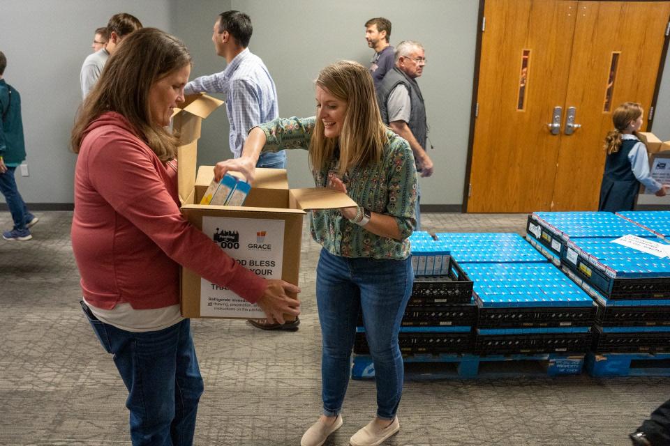 Jamie Paul and Darla Robbins pack one of 1,000 boxes at the Feed the 5,000 packing party held at Grace Baptist Church Wednesday Nov. 17, 2021.