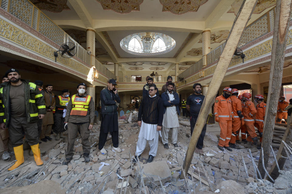 Rescue workers gather as they conduct an operation to clear the rubble and search for bodies at the site of Monday's suicide bombing, in Peshawar, Pakistan, Tuesday, Jan. 31, 2023. The death toll from the previous day's suicide bombing at a mosque in northwestern Pakistani rose to more than 85 on Tuesday, officials said. The assault on a Sunni Mosque inside a major police facility was one of the deadliest attacks on Pakistani security forces in recent years. (AP Photo/Muhammad Zubair)