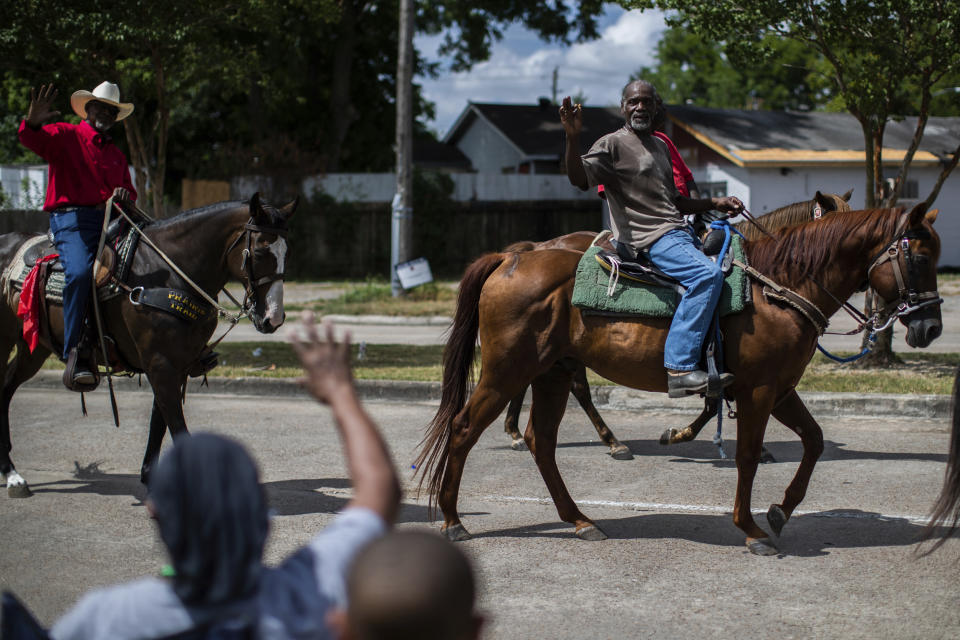 Members of the Acres Homes community wave at horse riders participating in the Mayor Turner's 9th Annual Juneteenth Parade, Saturday, June 18, 2022, in Houston. (Marie D. De Jesús/Houston Chronicle via AP)