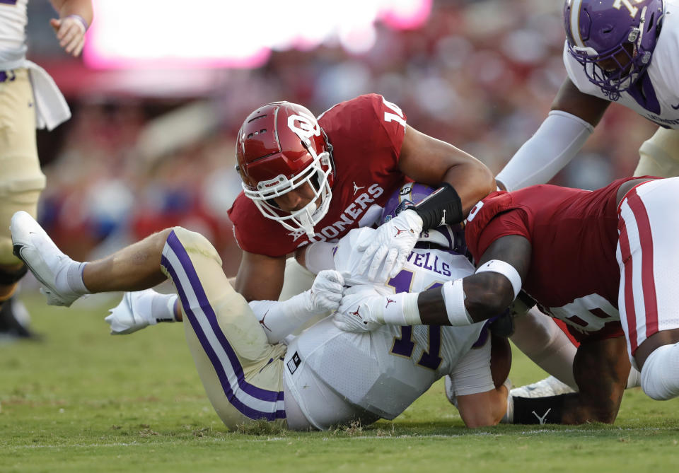 Oklahoma defensive end Reggie Grimes (14) and defensive lineman Perrion Winfrey (8) tackle Western Carolina quarterback Rogan Wells (11) during the first half of an NCAA college football game Saturday, Sept. 11, 2021, in Norman, Okla. (AP Photo/Alonzo Adams)