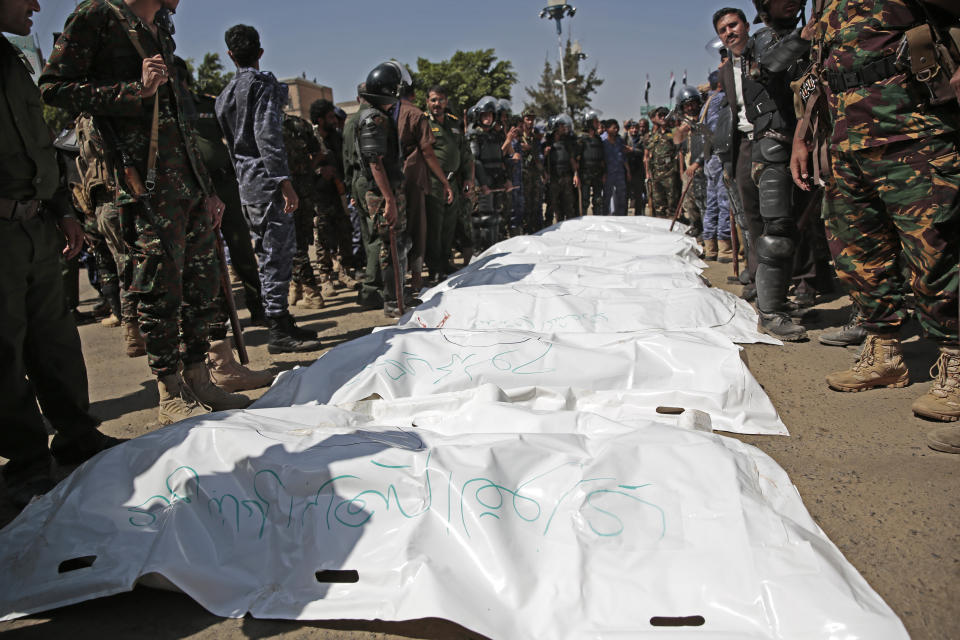 Police troopers stand around bags containing the bodies of nine men, convicted of involvement in the killing of a senior Houthi official Saleh al-Samad after their execution at Tahrir Square in Sanaa, Yemen Saturday, Sept. 18, 2021. Yemen's Houthi rebels on Saturday said they executed nine people for their alleged involvement in the killing of a senior Houthi official in an airstrike by the Saudi-led coalition more than three years ago. (AP Photo/Hani Mohammed)