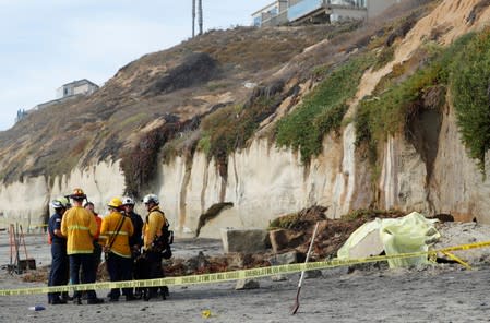 Emergency responders attend to a cliff collapse at a beach in Encinitas, California