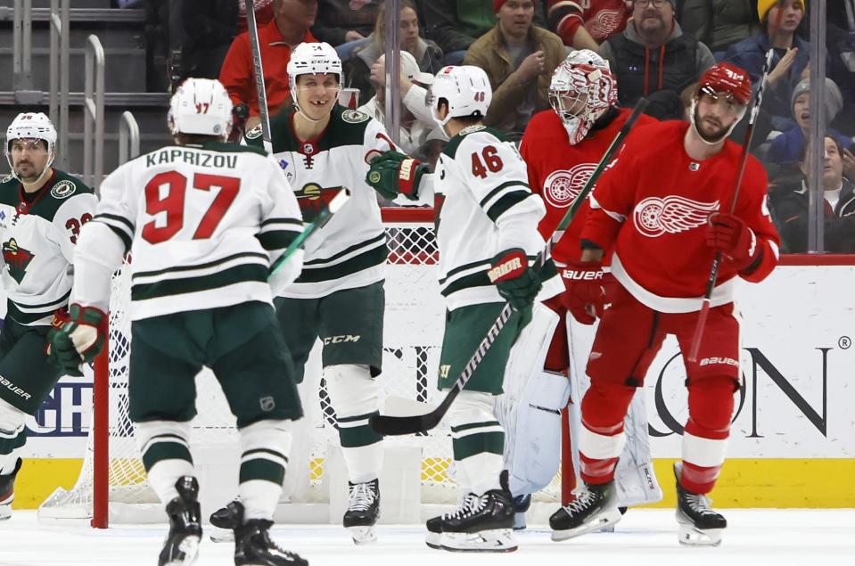Minnesota Wild center Joel Eriksson Ek, second from left, celebrates with left wing Kirill Kaprizov (97) and defenseman Jared Spurgeon (46) after scoring, with Detroit Red Wings goaltender Alex Lyon and defenseman Shayne Gostisbehere (41) skating off during the first period of an NHL hockey game Sunday, Nov. 26, 2023, in Detroit. (AP Photo/Duane Burleson)