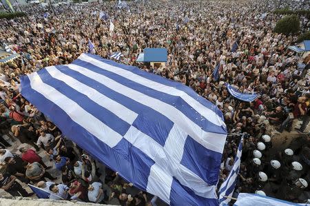 Protesters carry a gigantic Greek flag during a rally in front of the parliament building calling on the government to clinch a deal with its international creditors and secure Greece's future in the Eurozone, in Athens, Greece, June 22, 2015. REUTERS/Yiannis Liakos/Intimenews